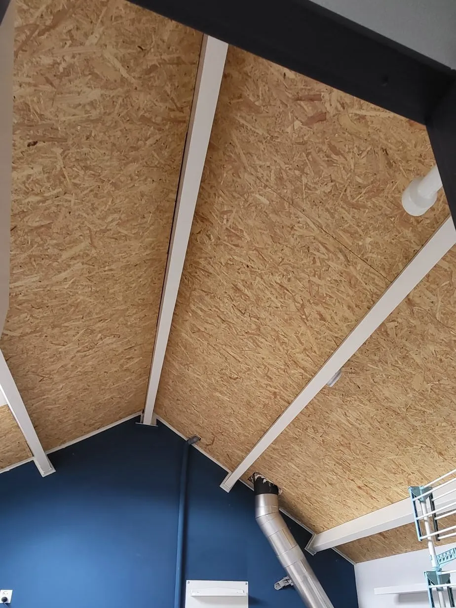 Nieuw dakbeschot van houtplaat aangebracht tegen de schuine dakhelling