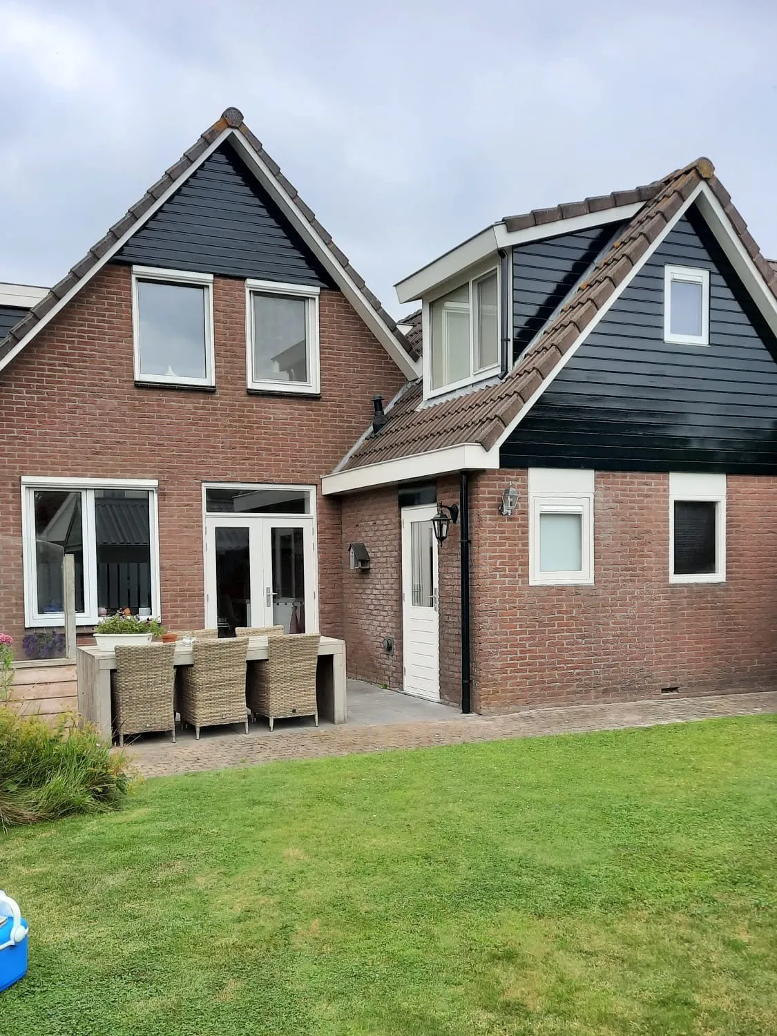 Achtergevel van een woonhuis met witte kozijnen en een donkere dakkapel